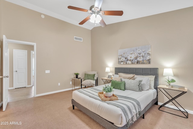 carpeted bedroom with ceiling fan and high vaulted ceiling