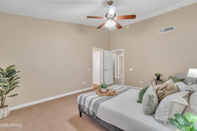 bedroom with ceiling fan, carpet floors, and a high ceiling