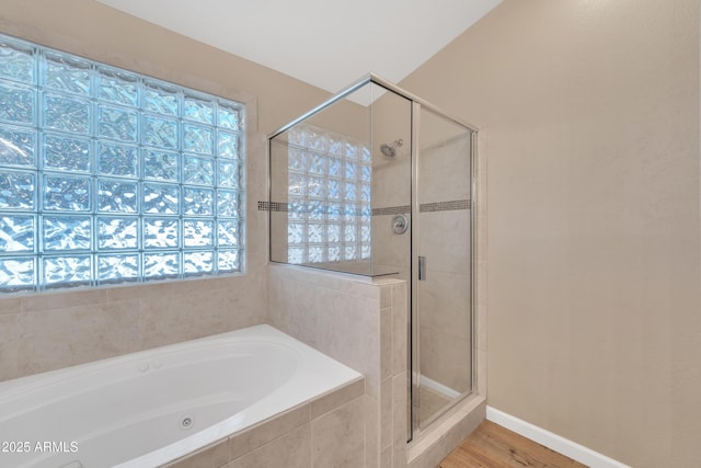 bathroom with hardwood / wood-style flooring, plus walk in shower, and a wealth of natural light