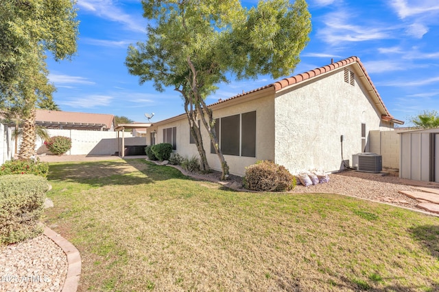 back of property featuring central AC and a lawn