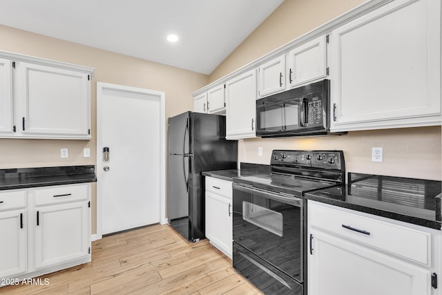 kitchen featuring white cabinetry, light hardwood / wood-style flooring, dark stone counters, and black appliances