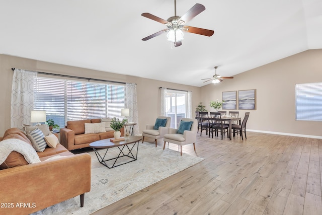 living room featuring ceiling fan, lofted ceiling, and light hardwood / wood-style floors