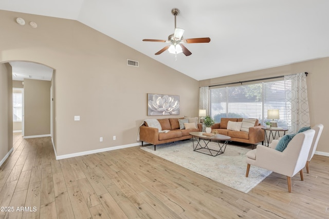 living room with light hardwood / wood-style flooring, high vaulted ceiling, and a healthy amount of sunlight