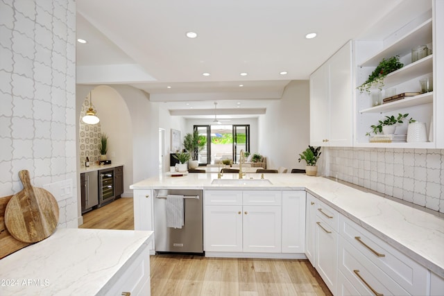 kitchen featuring dishwasher, light wood-type flooring, light stone counters, and sink