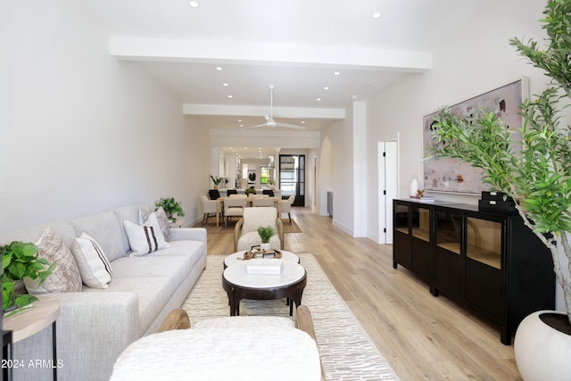 living room featuring beamed ceiling, light wood-type flooring, and ceiling fan