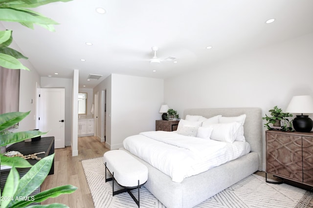 bedroom with ensuite bathroom and light hardwood / wood-style flooring