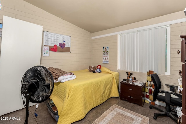 bedroom featuring lofted ceiling, brick wall, and tile patterned floors