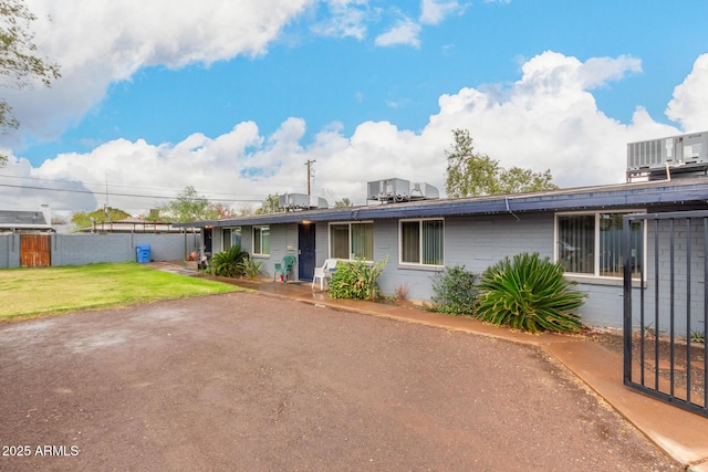 ranch-style house featuring a front yard and fence