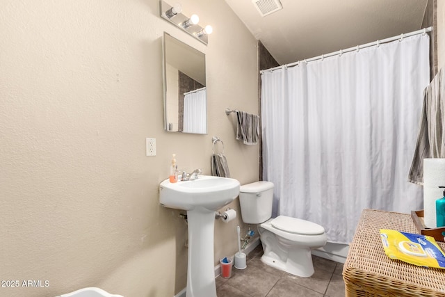 bathroom featuring visible vents, a sink, curtained shower, tile patterned floors, and toilet