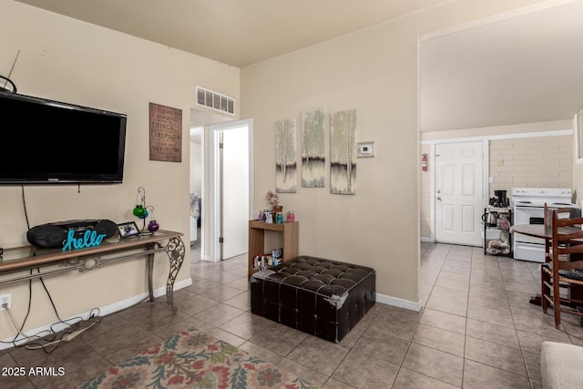 tiled living room with visible vents and baseboards