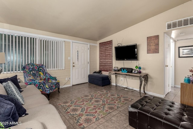 tiled living area with visible vents, baseboards, and lofted ceiling