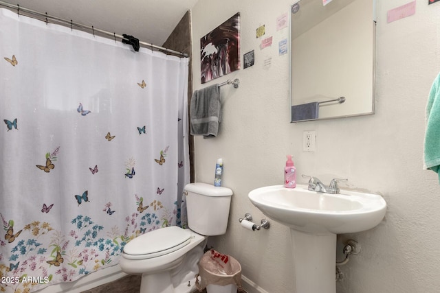 bathroom with a shower with shower curtain and toilet