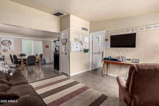 living area featuring lofted ceiling, baseboards, visible vents, and tile patterned floors