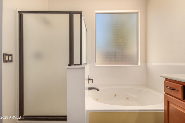 full bath featuring a jetted tub, a stall shower, and vanity