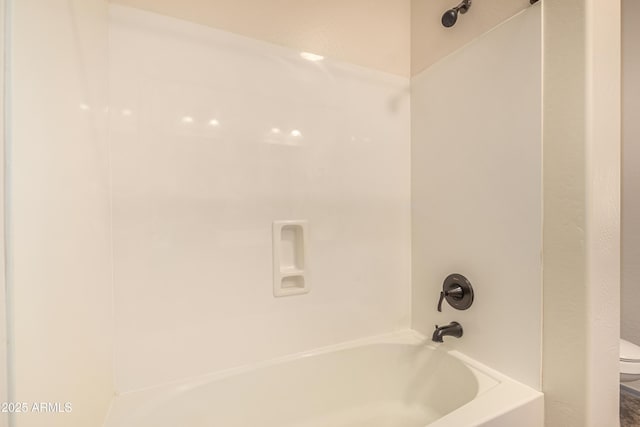 bathroom with bathtub / shower combination and toilet