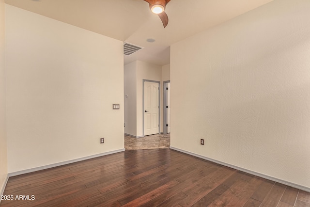 unfurnished room featuring a ceiling fan, wood finished floors, visible vents, and baseboards