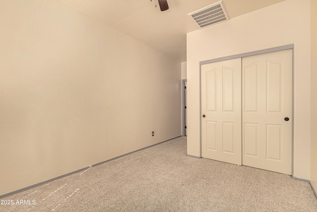 unfurnished bedroom with light carpet, visible vents, baseboards, a ceiling fan, and a closet