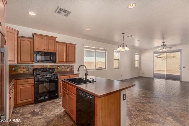 kitchen with dark countertops, visible vents, a sink, and black appliances