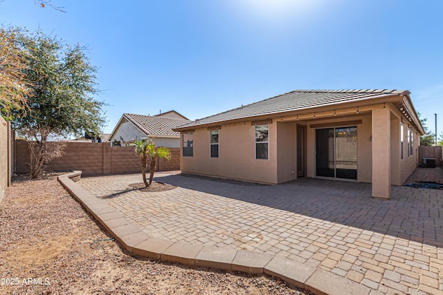 rear view of house with a patio area, a fenced backyard, a tiled roof, and stucco siding