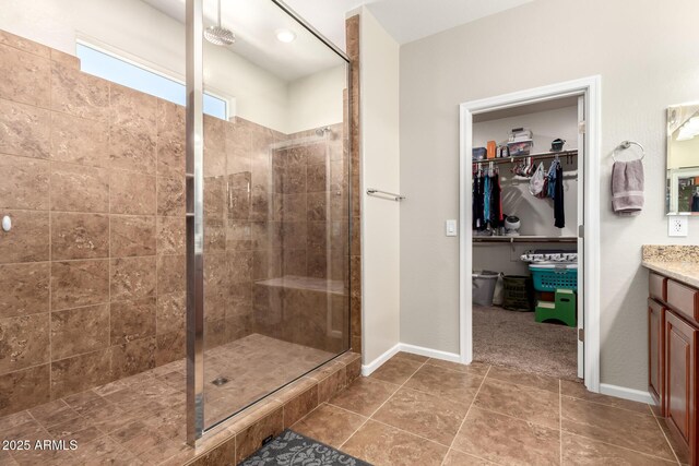 13123 W Cottontail Ln, Peoria, AZ 85383 - full bath featuring a tile shower, vanity, a walk in closet, and baseboards