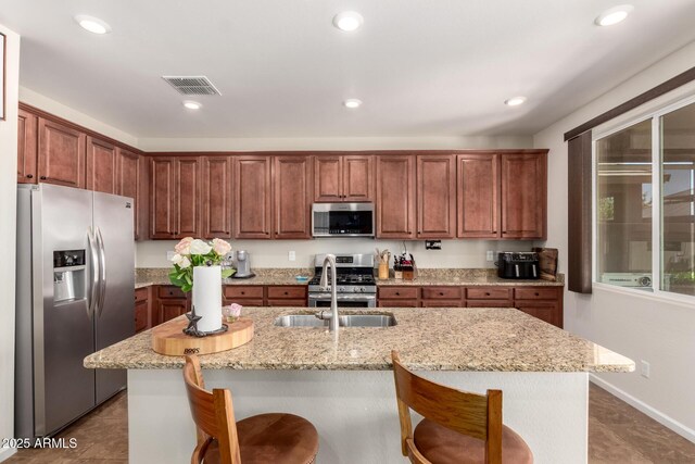 13123 W Cottontail Ln, Peoria, AZ 85383 - kitchen with appliances with stainless steel finishes, a kitchen breakfast bar, light stone counters, and recessed lighting