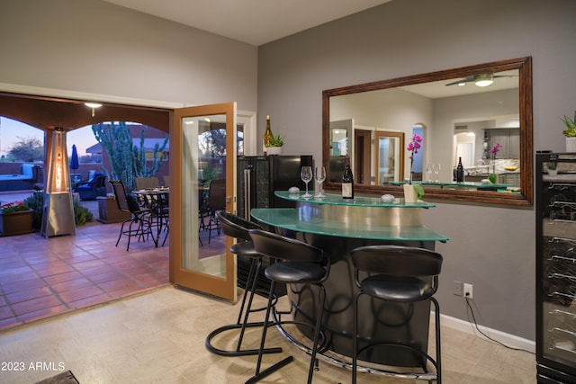 bar featuring beverage cooler and light tile patterned flooring