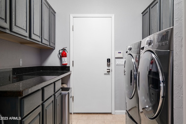 clothes washing area featuring cabinets and washing machine and dryer