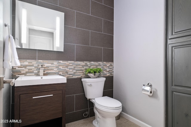 bathroom with vanity, decorative backsplash, and toilet