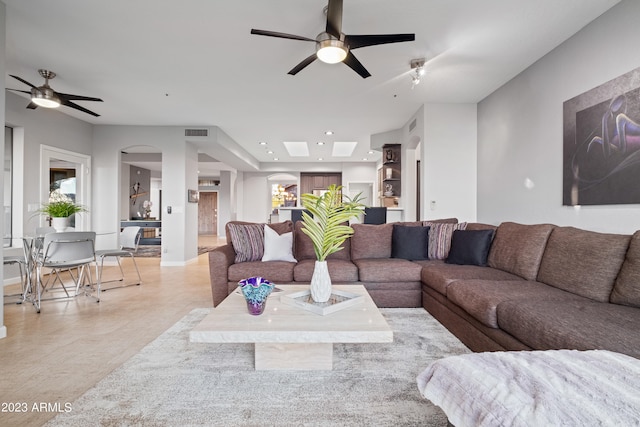 living room with ceiling fan and built in shelves