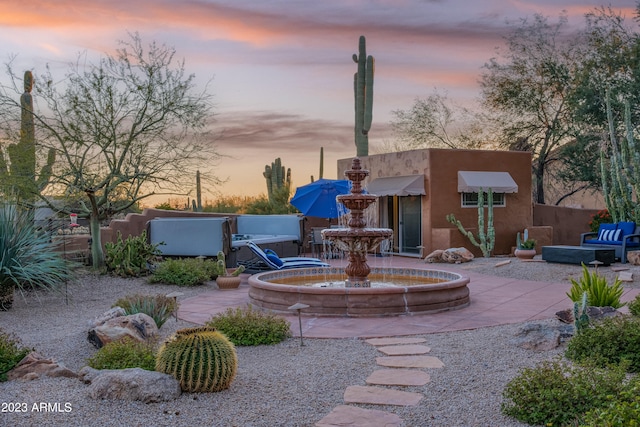 back house at dusk with a jacuzzi