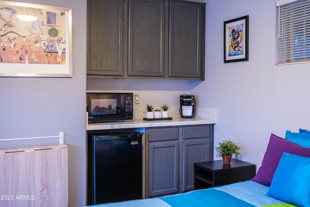 bar featuring dark brown cabinets and fridge