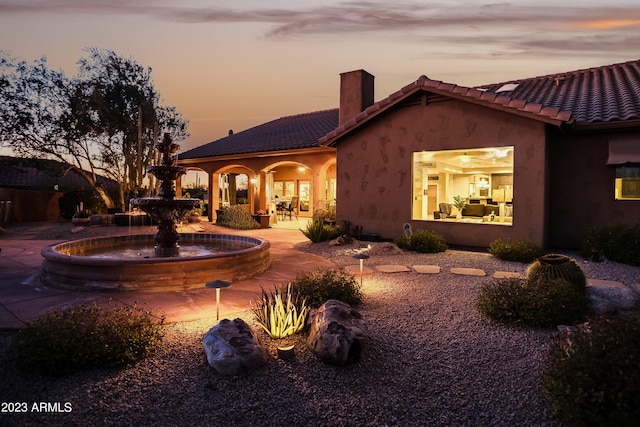 back house at dusk with a patio