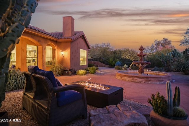 patio terrace at dusk featuring a fire pit