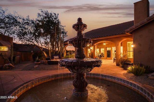 pool at dusk with a patio area