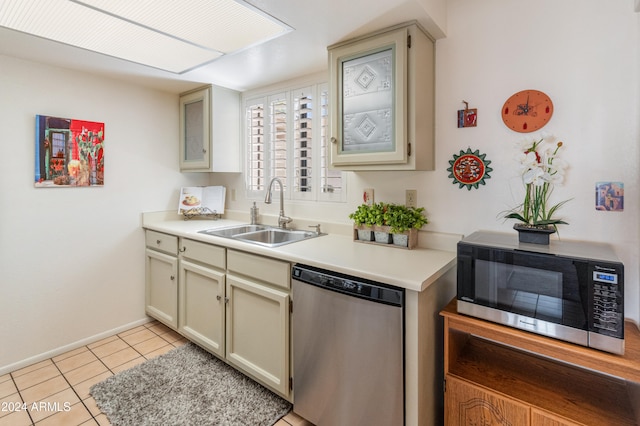 kitchen featuring cream cabinetry, stainless steel appliances, sink, and light tile patterned floors