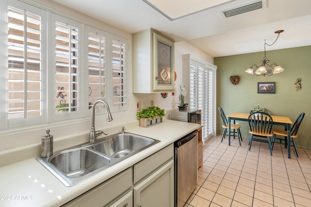 kitchen featuring stainless steel dishwasher, light tile patterned floors, pendant lighting, and a wealth of natural light