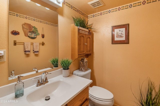 bathroom featuring vanity, toilet, and a textured ceiling