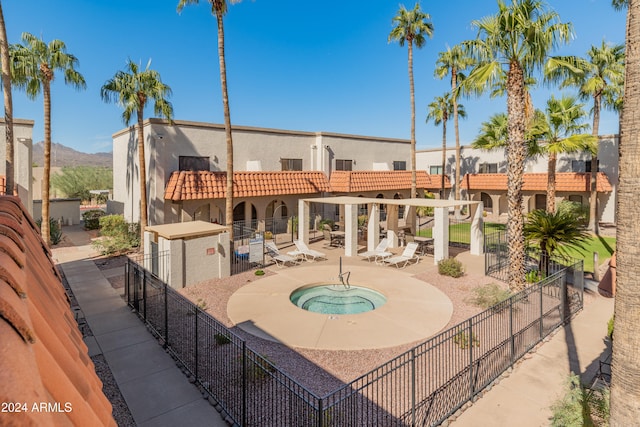 view of swimming pool featuring a hot tub, a mountain view, and a patio area