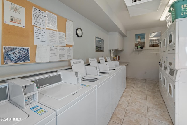 laundry area with stacked washer and dryer, light tile patterned flooring, and washing machine and dryer