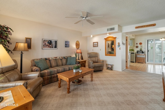 carpeted living room with ceiling fan and a textured ceiling