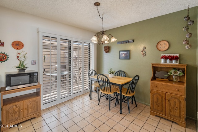 dining room featuring light tile patterned flooring, a notable chandelier, and a textured ceiling