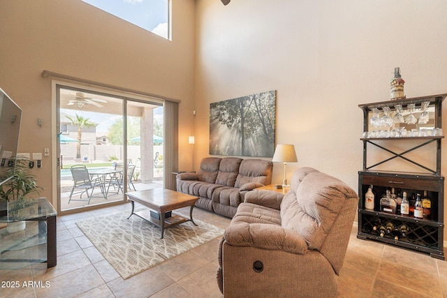 tiled living area featuring a towering ceiling and ceiling fan