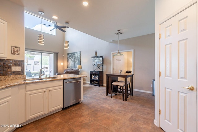 kitchen with a ceiling fan, dishwasher, a sink, white cabinets, and open floor plan