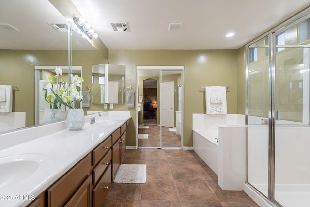 full bathroom featuring visible vents, a sink, a garden tub, and a shower stall