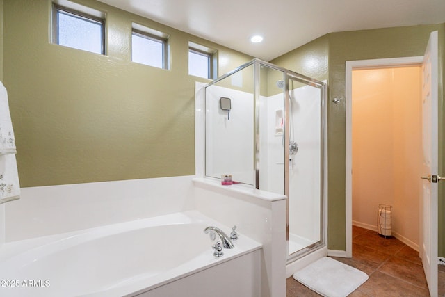bathroom featuring tile patterned floors, a garden tub, and a stall shower