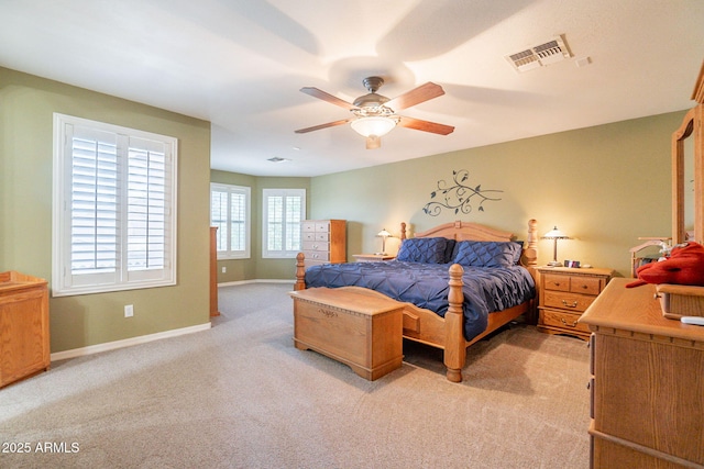 bedroom featuring visible vents, a ceiling fan, baseboards, and light carpet