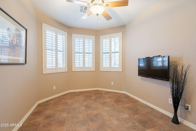 tiled empty room with baseboards, ceiling fan, visible vents, and a wealth of natural light