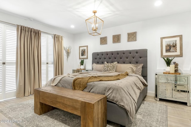 bedroom featuring light hardwood / wood-style flooring and an inviting chandelier