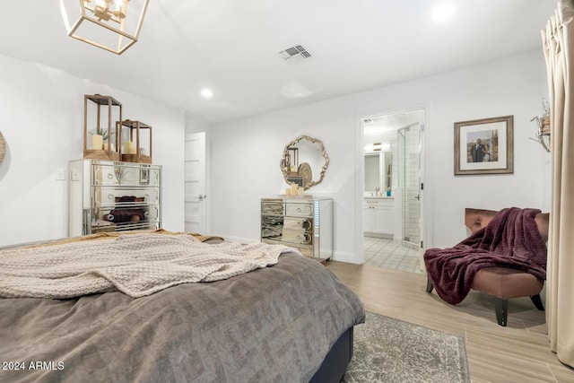 bedroom featuring light wood-type flooring and connected bathroom