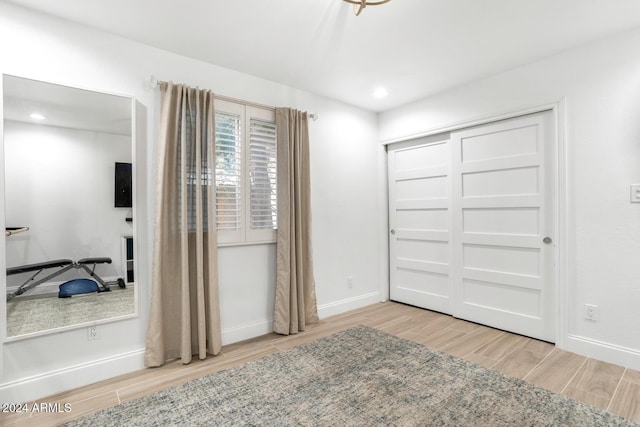 bedroom featuring light wood-type flooring and a closet